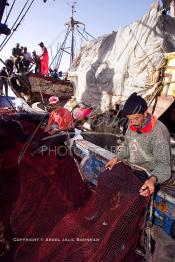 Image du Maroc Professionnelle de  Des ouvriers s'activent à réparer leurs filets de pêches au port de Laayoune, située à quelque kilomètre de la ville de Laayoune capitale du Sahara marocain, Vendredi 21 Septembre 2001. (Photo / Abdeljalil Bounhar)